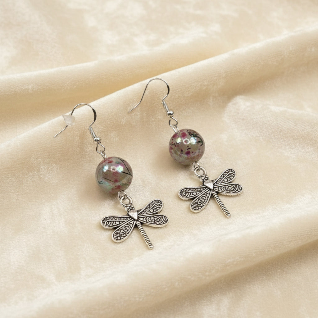 Detailed view of handmade oriental-style beaded earrings with dragonfly accent