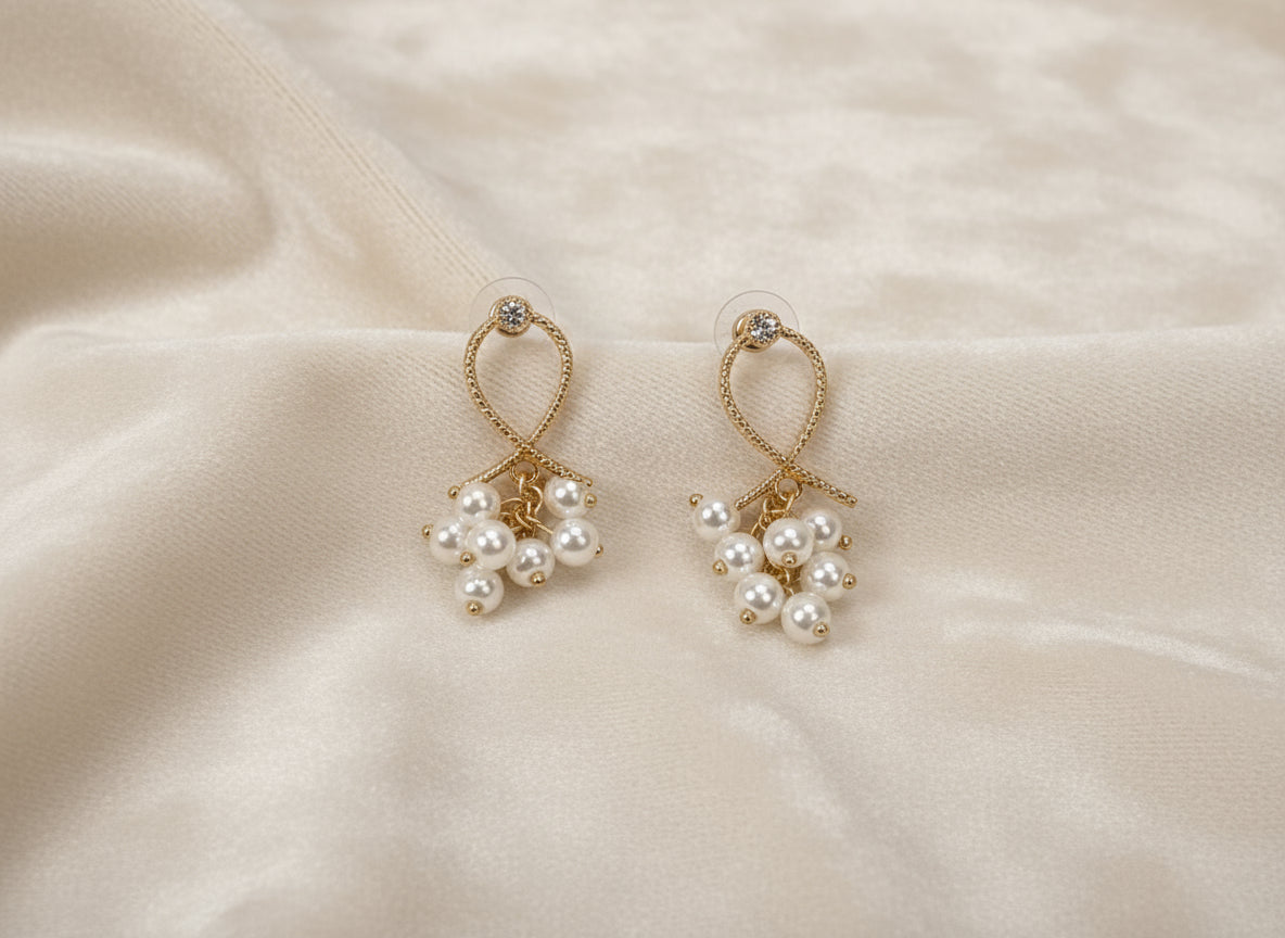 Pair of pearl earrings on a beige fabric background