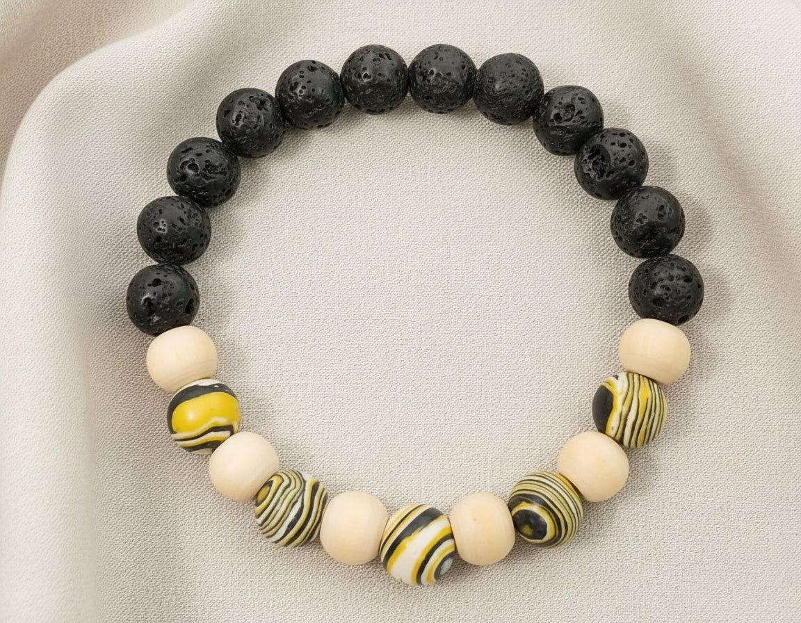 Bracelet with black, white, and yellow beads on a beige fabric background
