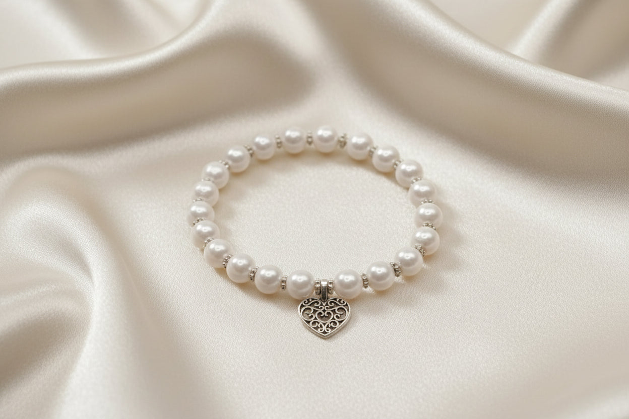 Close-up of pearl bracelet with hollow heart charm and silver accent spacers