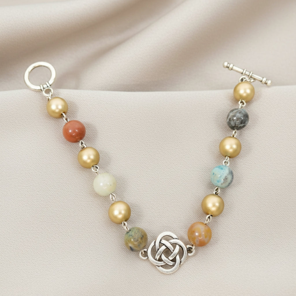 Multicolored beaded bracelet with a silver clasp on a beige fabric background