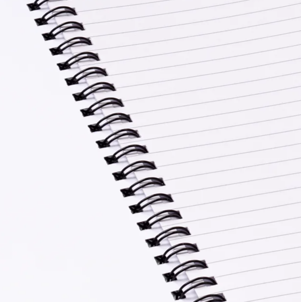 Close-up of a spiral-bound notebook with lined pages on a white background