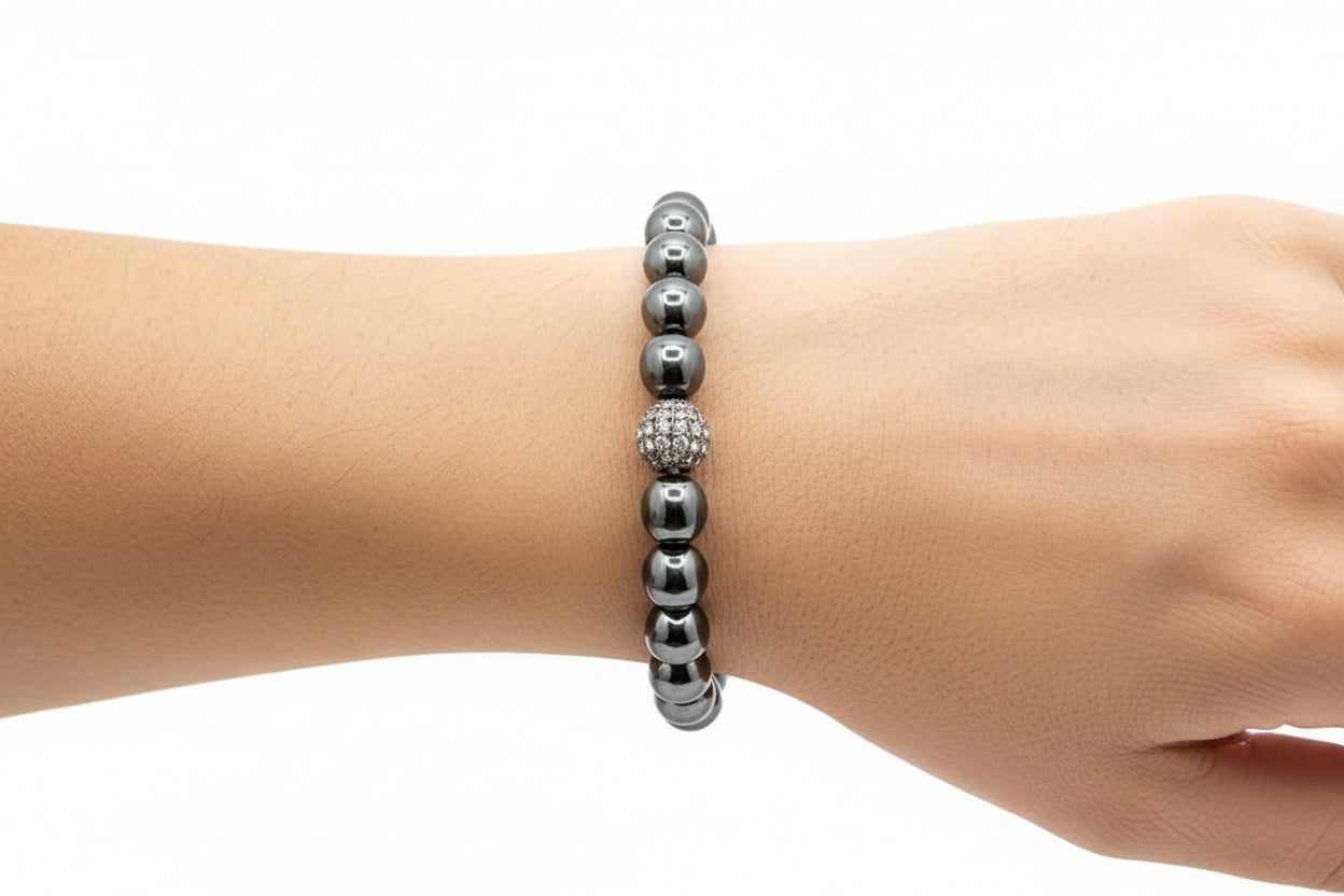 Gray beaded bracelet on a wrist against a white background