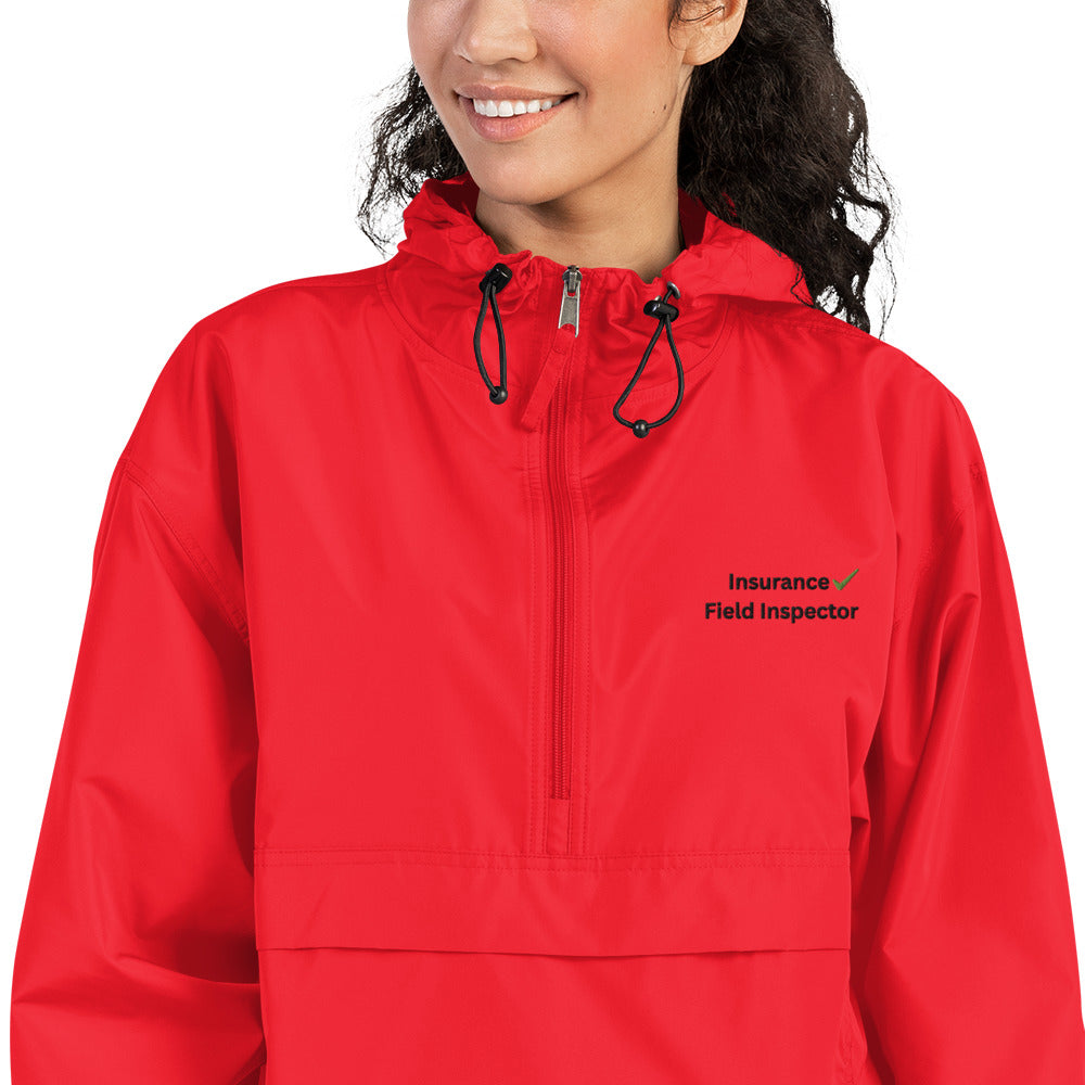 Close up of scarlet Champion packable windbreaker jacket showing embroidered field inspector design