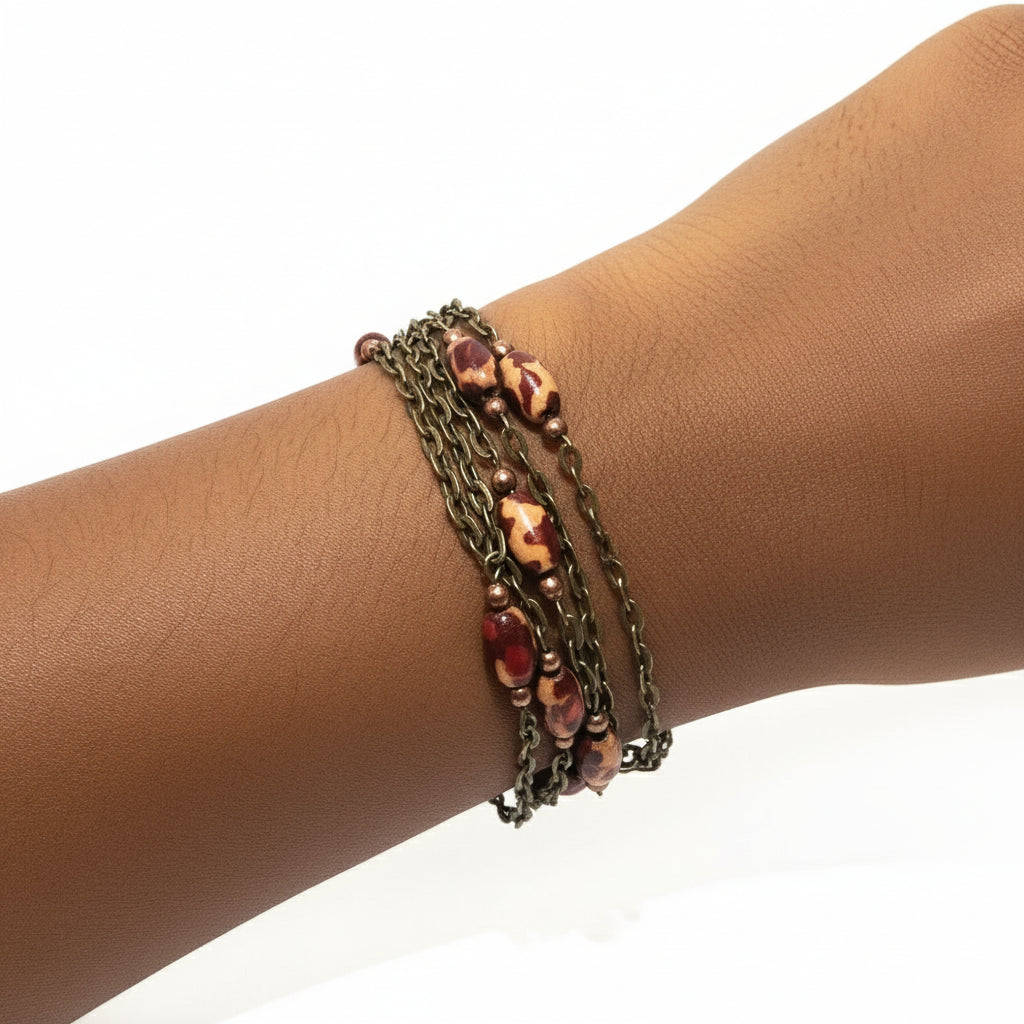Multistrand bracelet with beads on a wrist against a white background