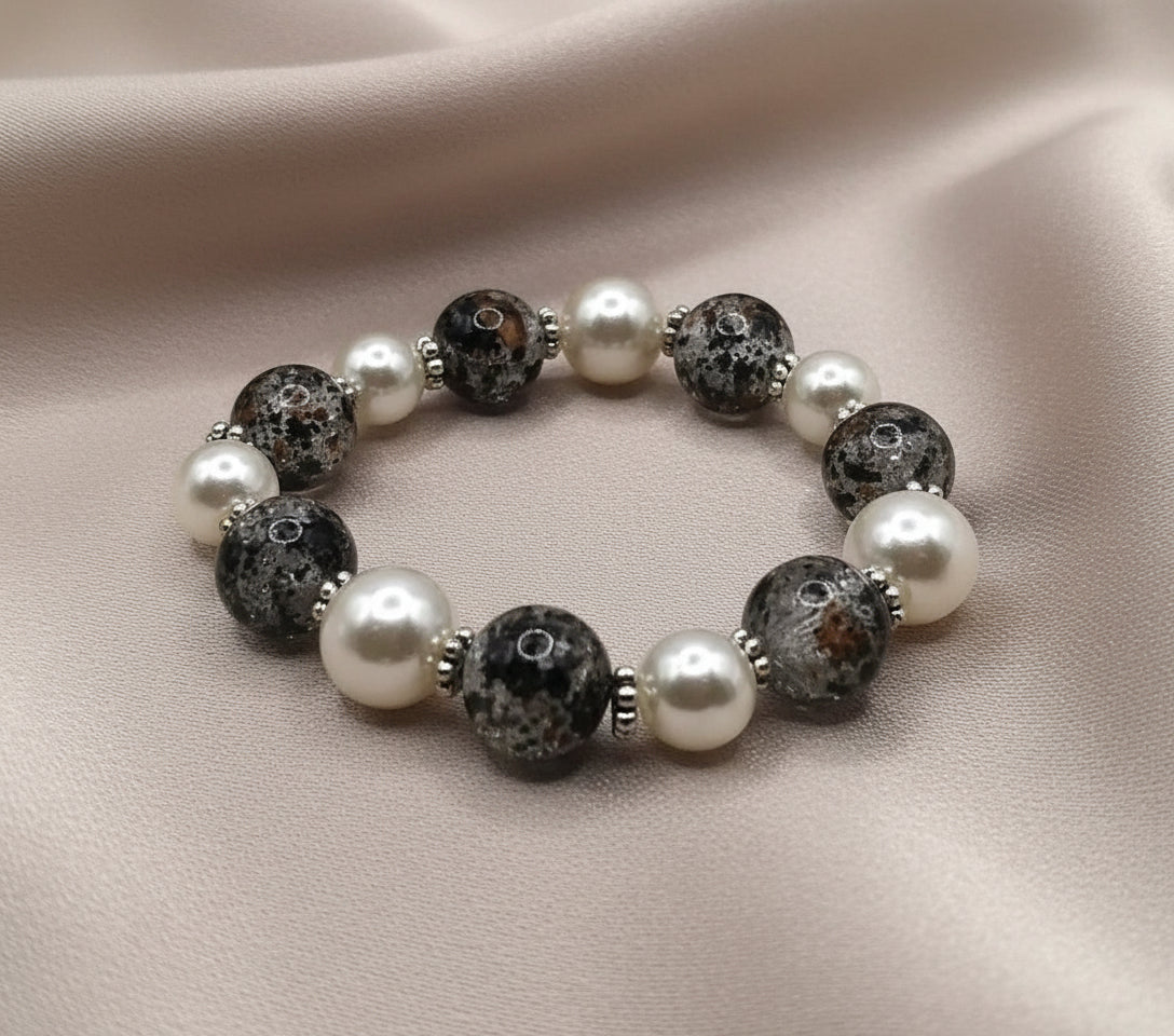 Close-up of crackle glass bead and pearl bracelet with stretch cord design