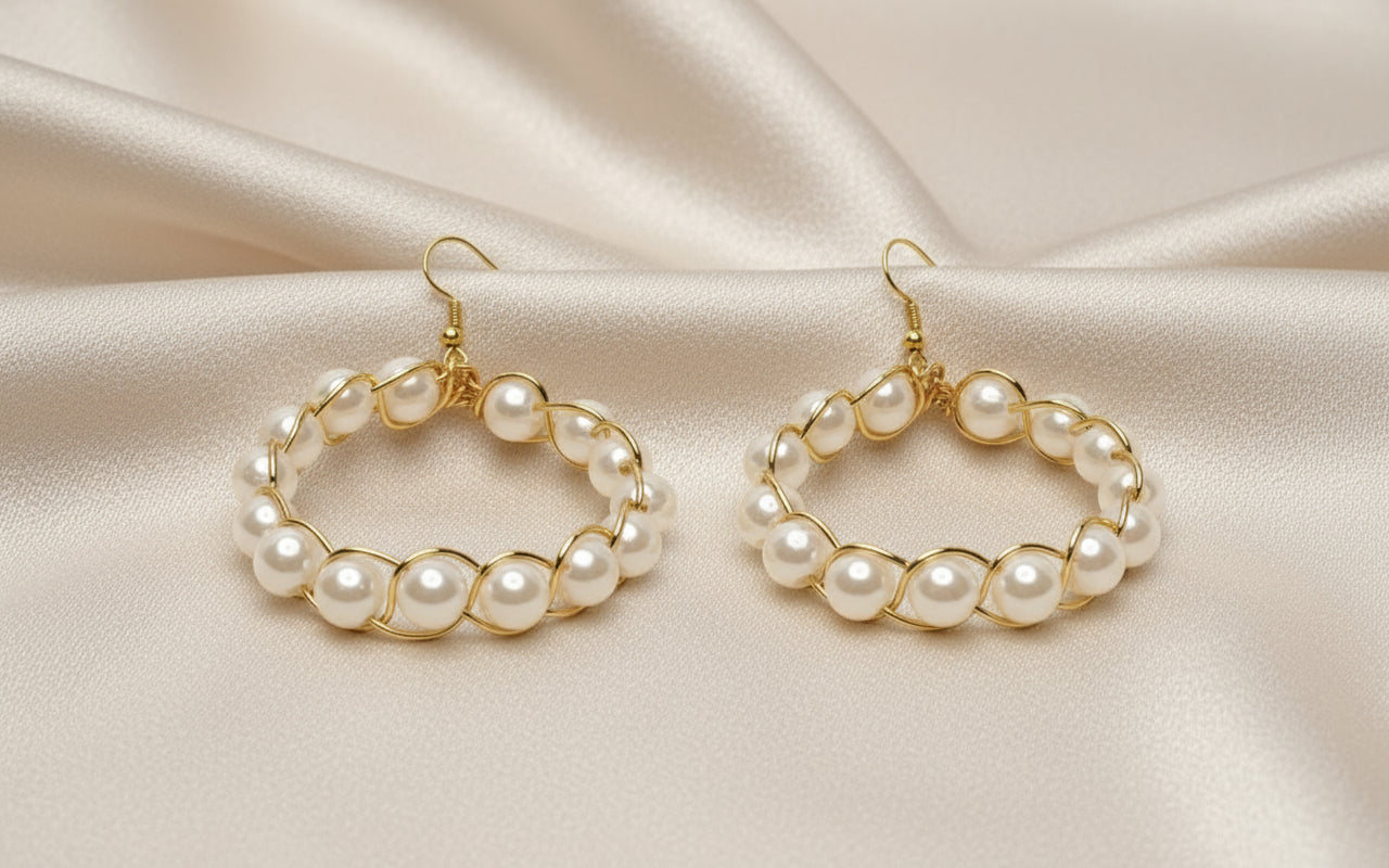 Close-up of gold copper braided hoop earrings featuring pearl beads