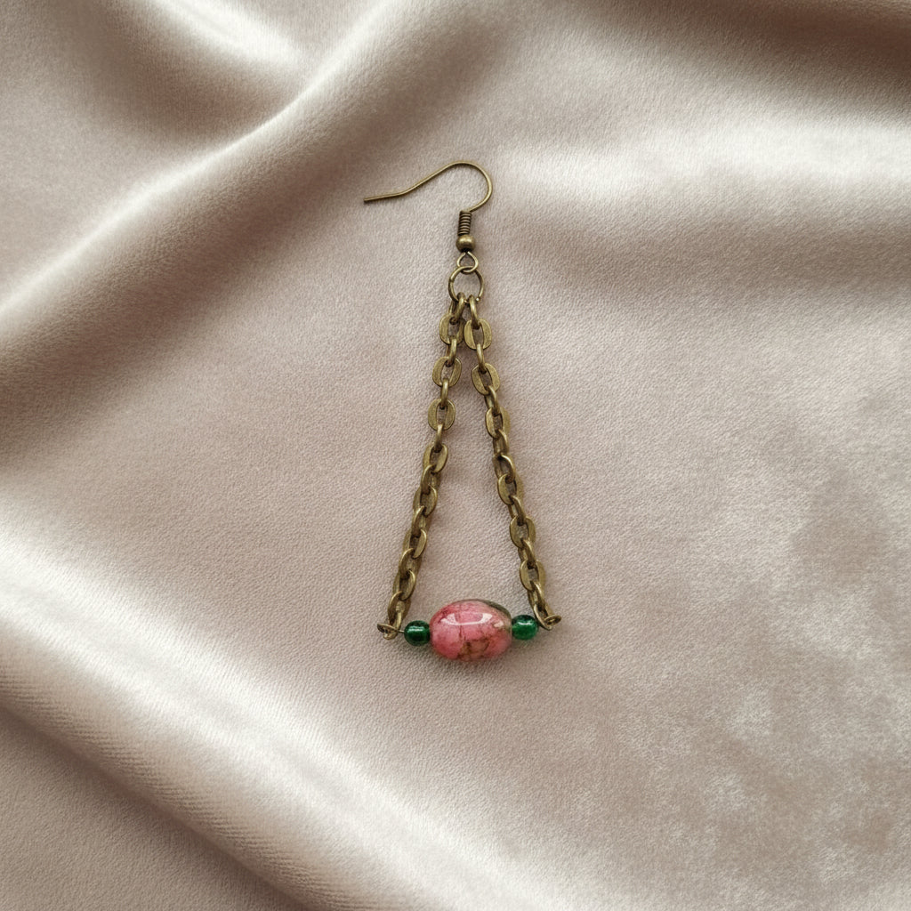 Close-up of bronze chainlink earrings with pink and green glass beads