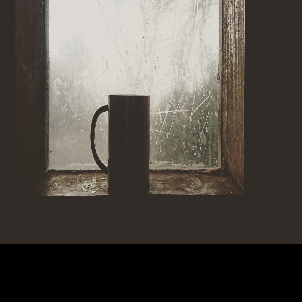 CERAMIC MUG SITTING IN WINDOW