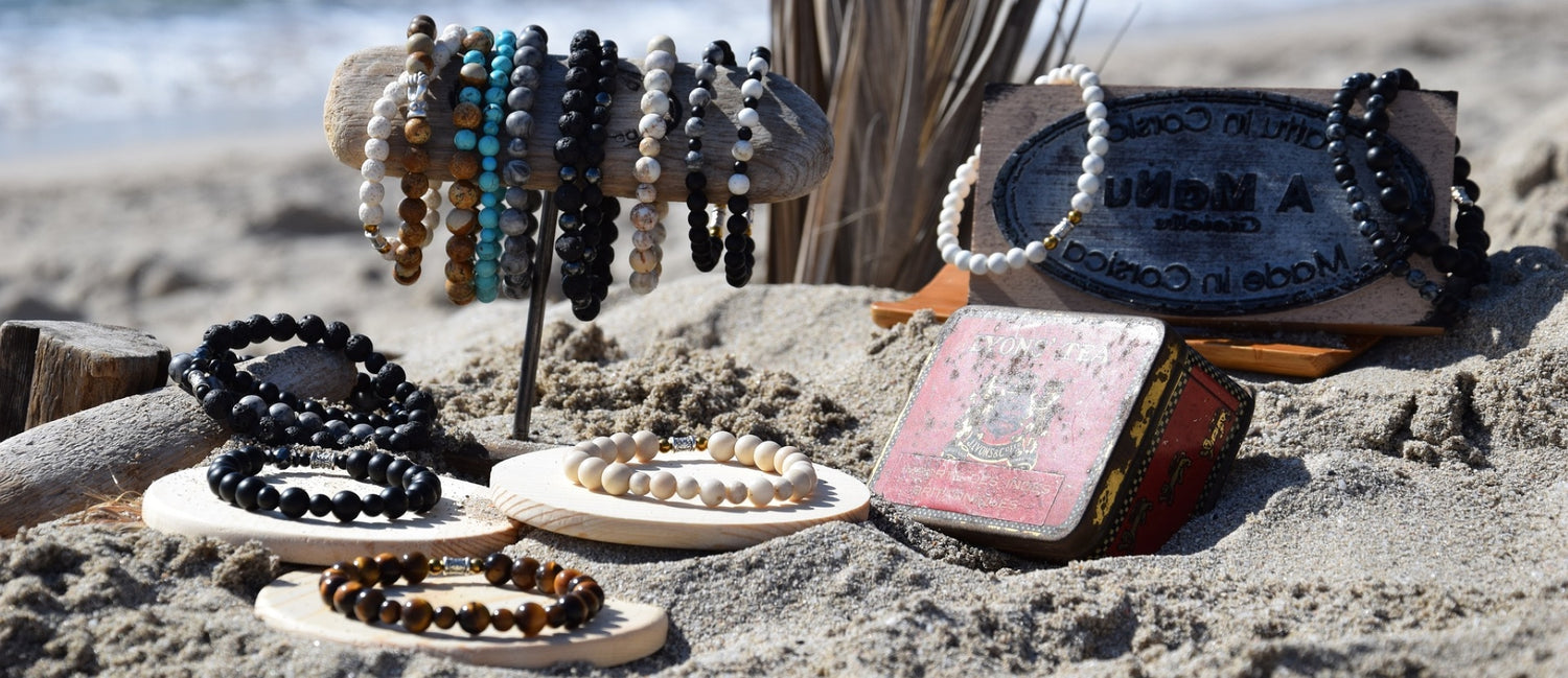 Man reaching hand out showing beaded and gemstone bracelets