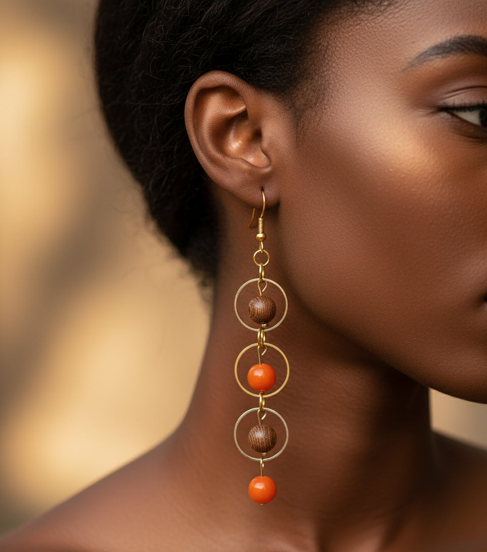 Close-up of three-layer gold hoop earrings with natural wood and orange chakra beads