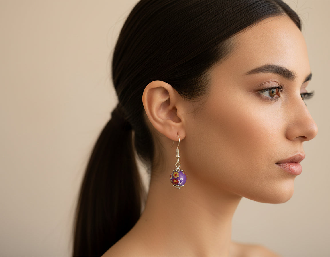 Woman wearing handmade polymer clay dangling earrings with floral stoppers
