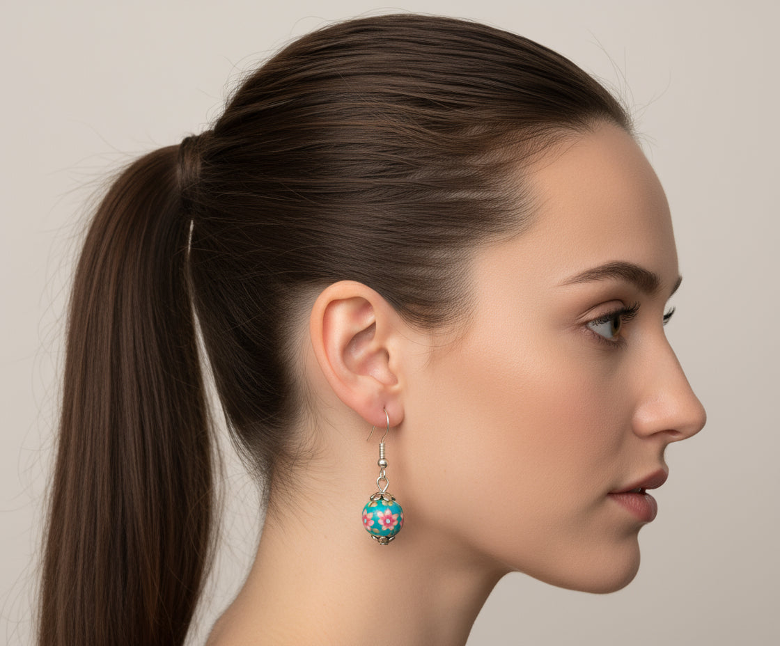 Woman wearing handmade polymer clay dangling earrings with floral stoppers