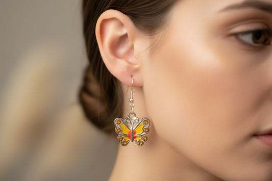 Butterfly earrings worn by a person with a blurred background