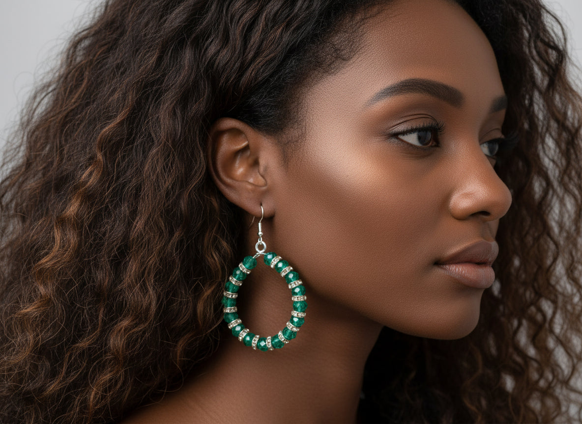 Woman wearing green hoop earrings with a neutral background