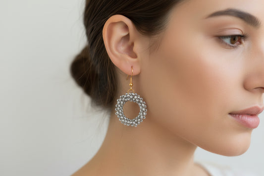 Close-up of a woman wearing a silver hoop earring with a blurred background