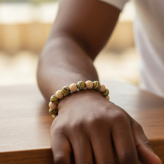Hand wearing a beaded bracelet on a wooden surface
