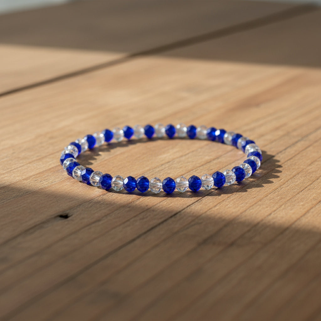 Beaded bracelet with blue and clear beads on a wooden surface