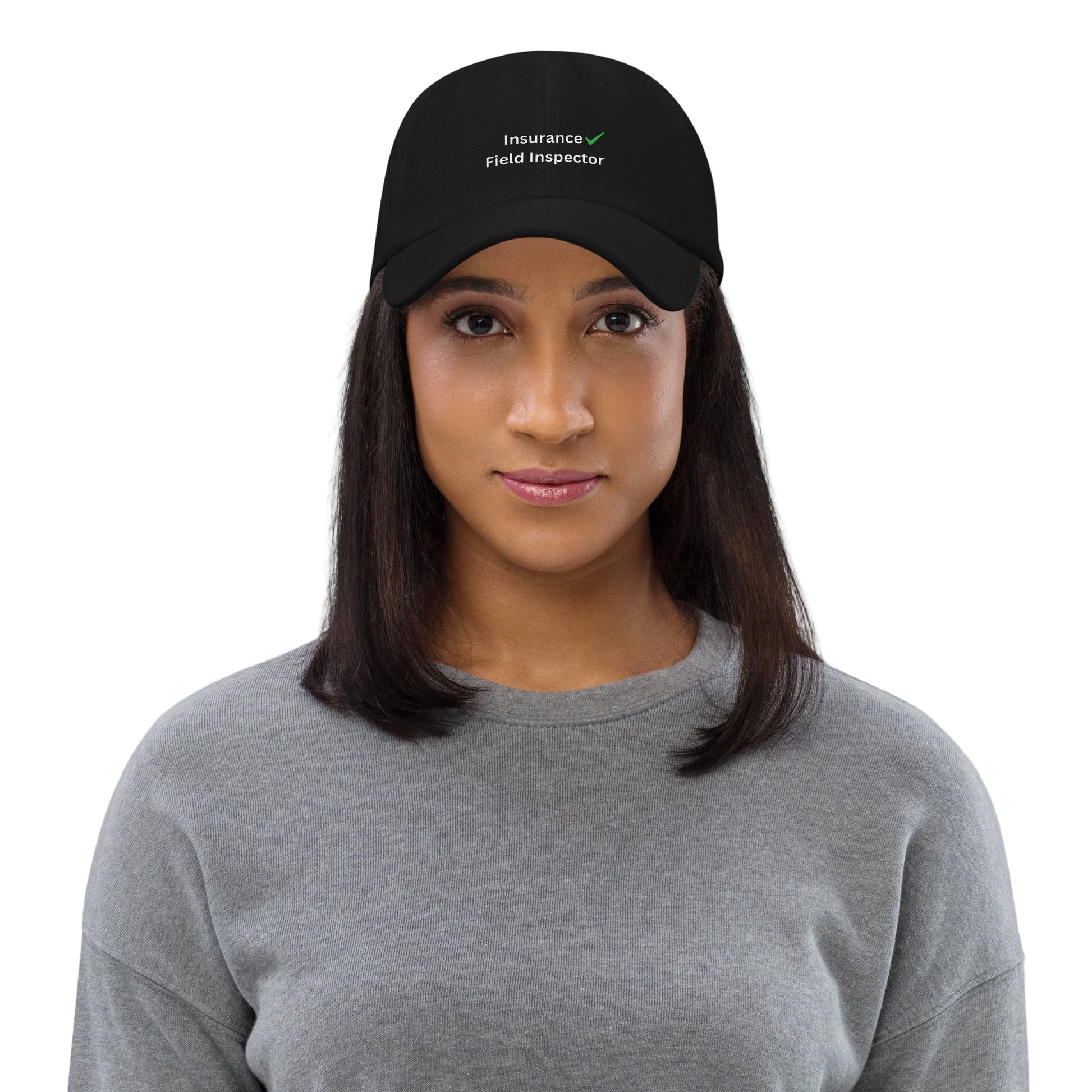 Woman wearing a black cap with 'Insurance Field Inspector' text on a gray background