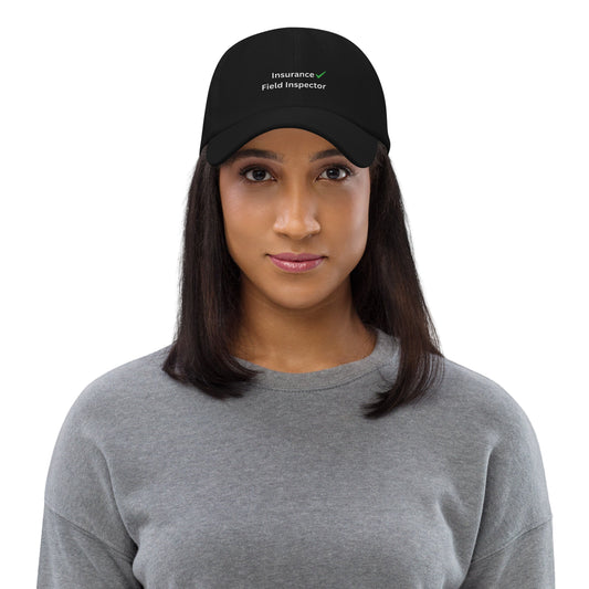 Woman wearing a black cap with 'Insurance Field Inspector' text on a gray background