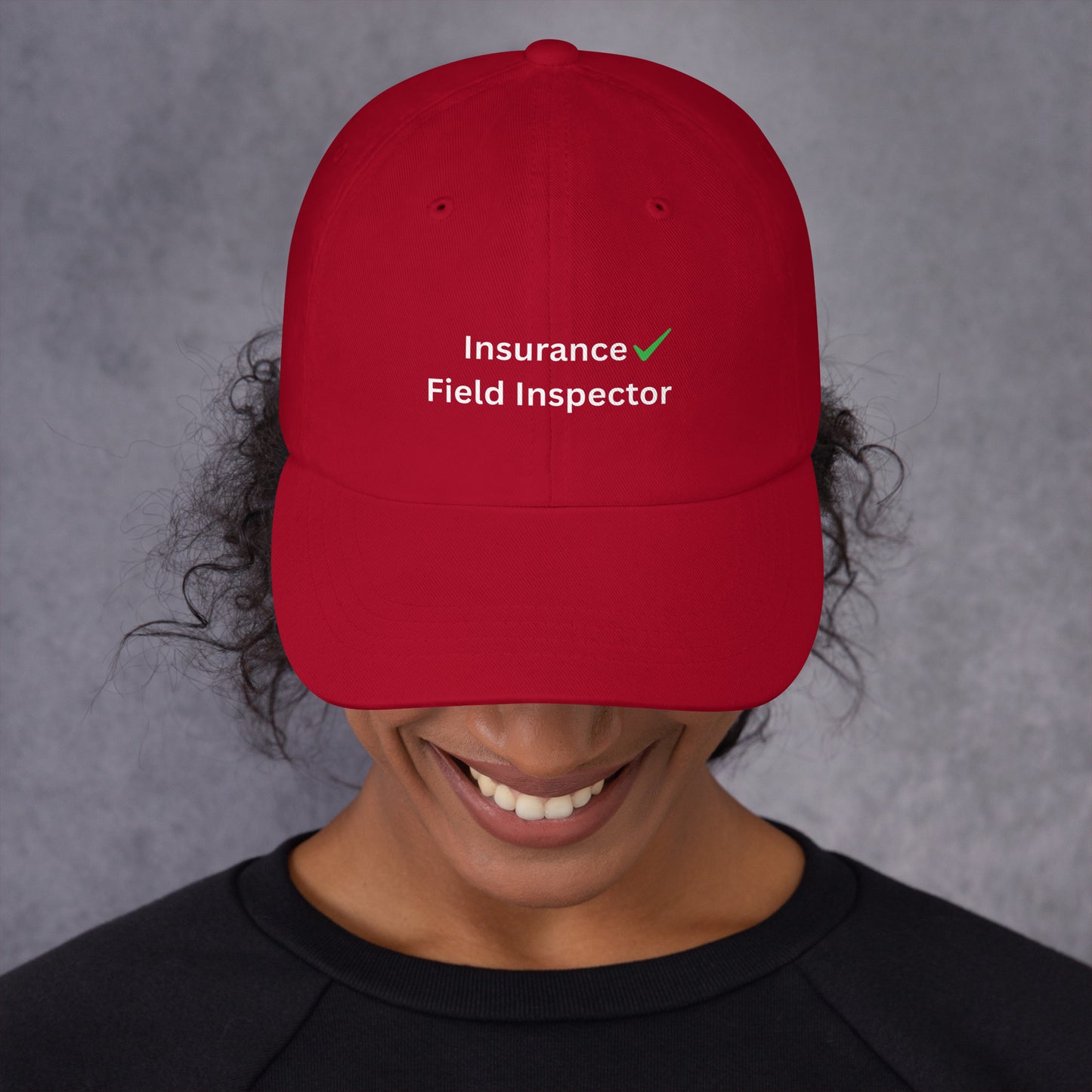 Person wearing a red cap with 'Insurance Field Inspector' text on a gray background