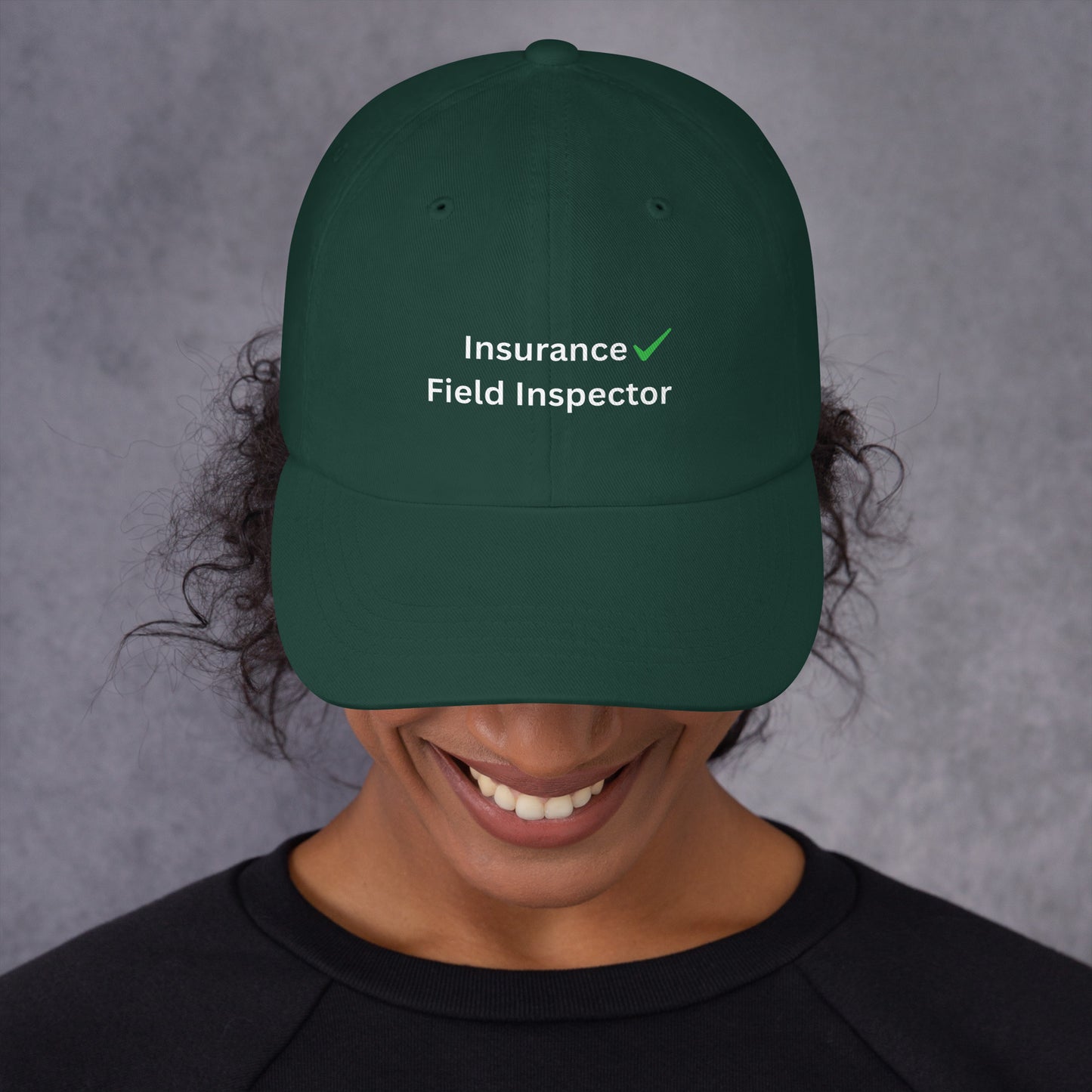 Person wearing a green cap with 'Insurance Field Inspector' text on a gray background