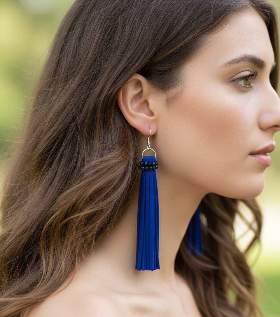 Woman wearing handmade long blue faux leather tassel earrings with crystal bead accents