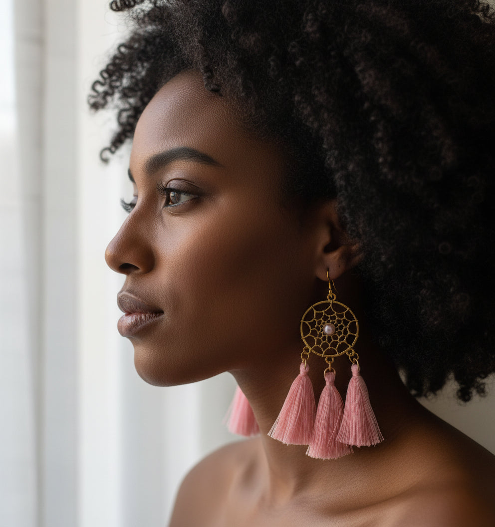 Woman wearing pink tassel earrings with a neutral background