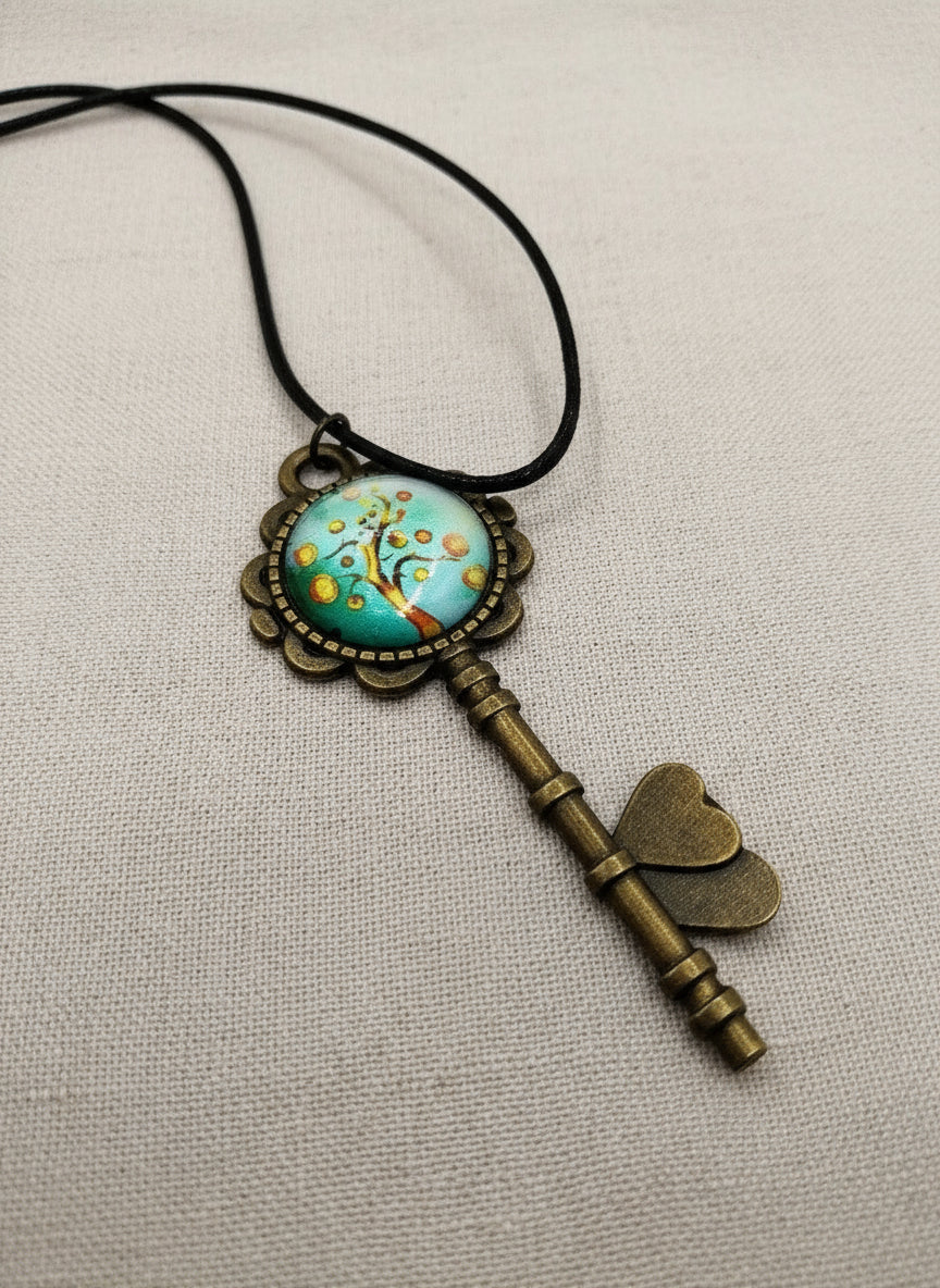Decorative key-shaped pendant with a tree of life design on a beige background