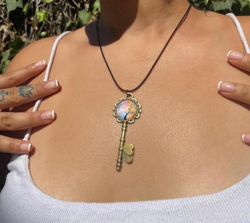 Necklace with a decorative key pendant worn by a person outdoors
