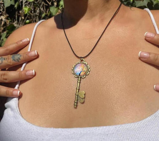 Necklace with a decorative key pendant worn by a person outdoors