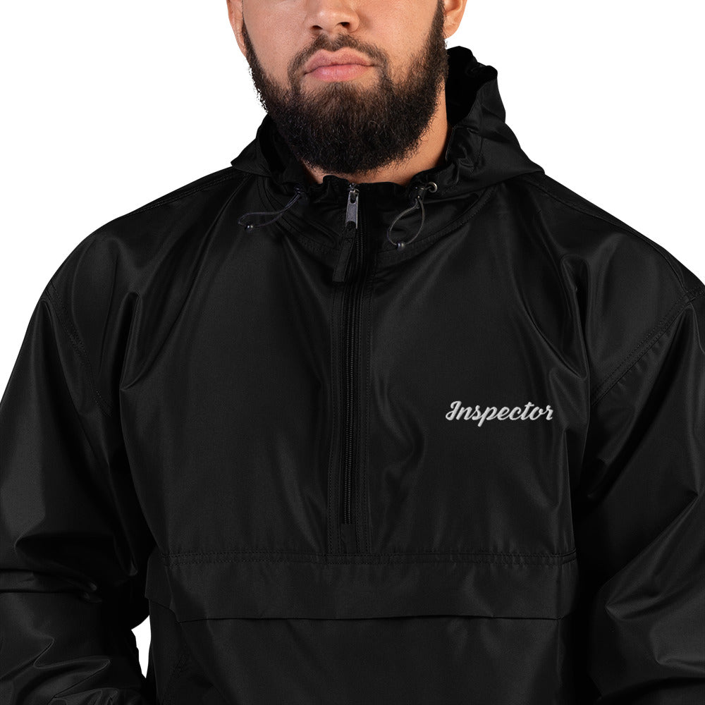 Close up of black Champion packable jacket showing embroidered Field Inspection logo