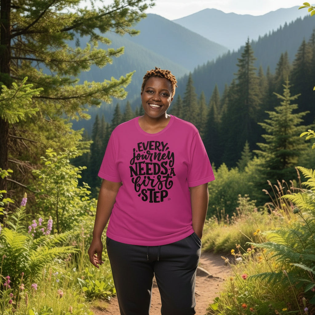 Person wearing a pink t-shirt with a motivational quote in a forest setting