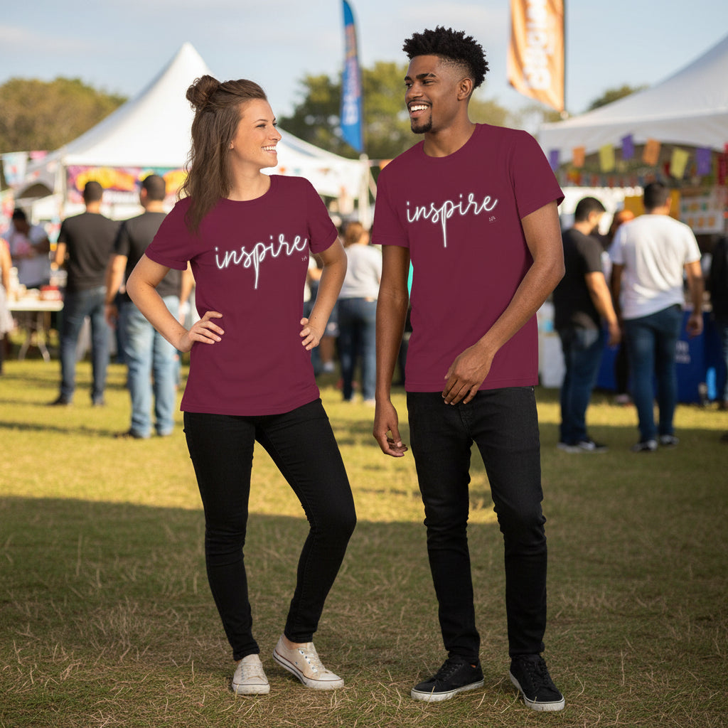 Two people wearing 'inspire' t-shirts at an outdoor event.