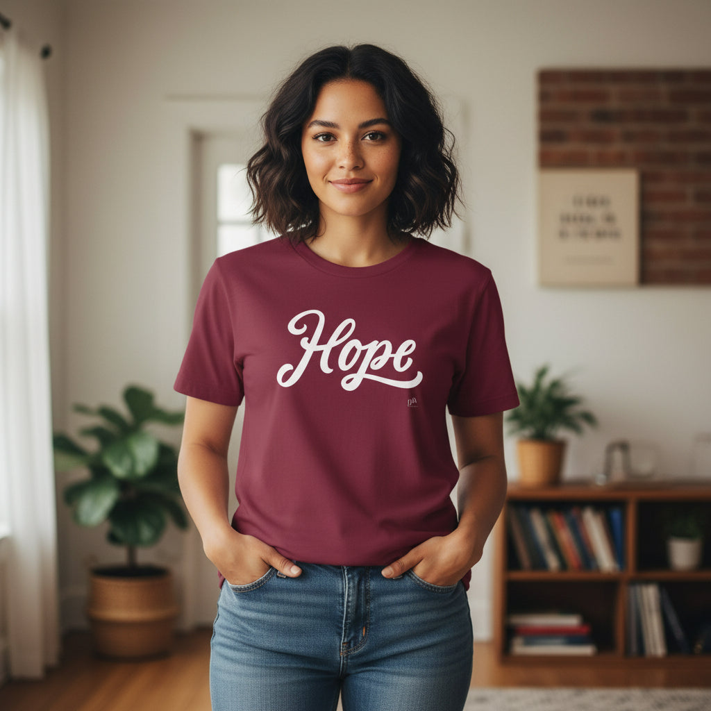 Woman wearing a maroon t-shirt with 'Hope' printed on it in a room with plants and books.