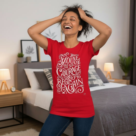 Woman wearing a red t-shirt with motivational text in a bedroom