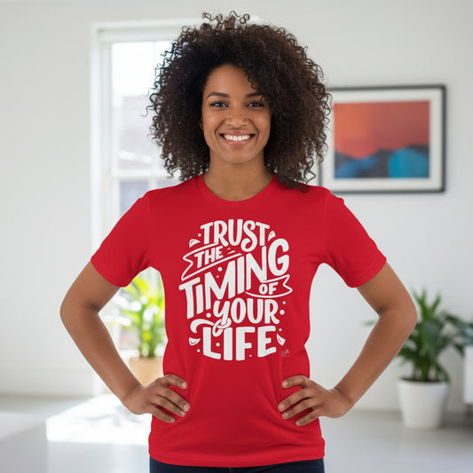Person wearing a red t-shirt with motivational quote in a room with plants and a painting.