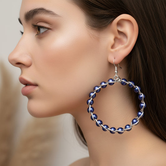 Close-up of woman wearing handmade braided hoop earrings with colorful beads