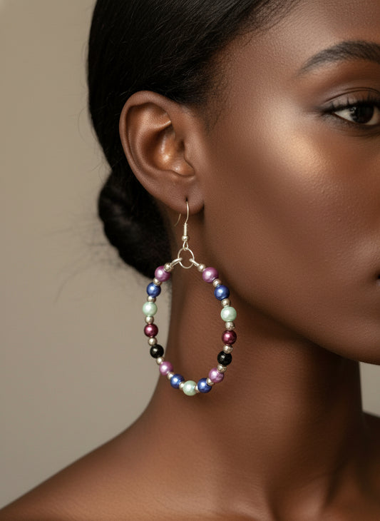 Woman wearing handmade aluminum wire hoop earrings with five colorful beads