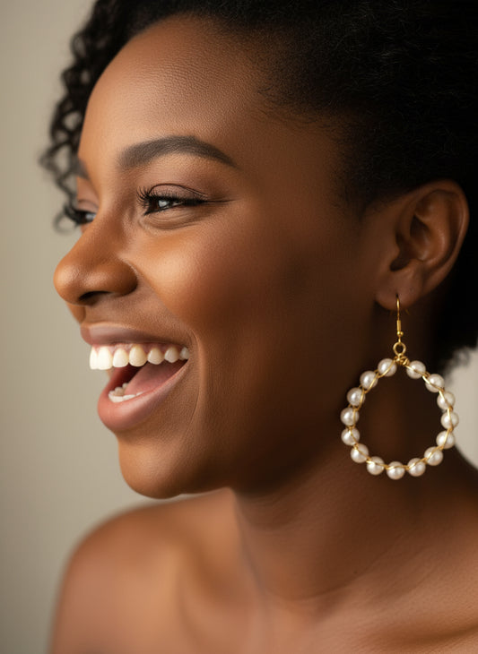 Woman wearing handmade copper wire wrapped beaded hoop earrings with ivory pearls