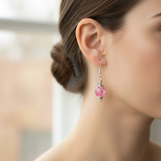 A woman wearing handmade pink aluminum wire wrapped earrings with crackle beads