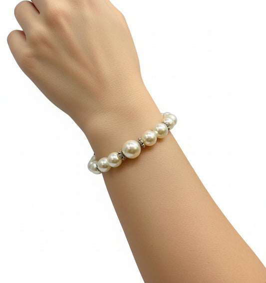 Pearl bracelet on a wrist against a wooden background