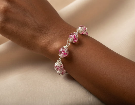 Bracelet with pink beads on a wrist against a beige background